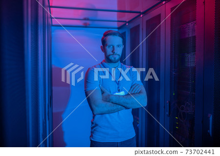 Calm man standing with folded arms on chest 73702441