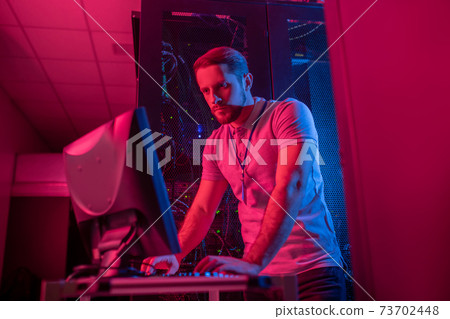 Man working on computer in data center Man working on computer in data center 73702448