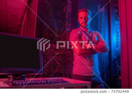 Serious man with badge in the datacenter Serious man with badge in the datacenter 73702449
