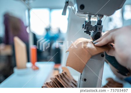 woman work with sewing machinery on shoe factory 73703497