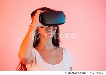 Young woman with virtual reality headset on eyes smiling from close up 73703557