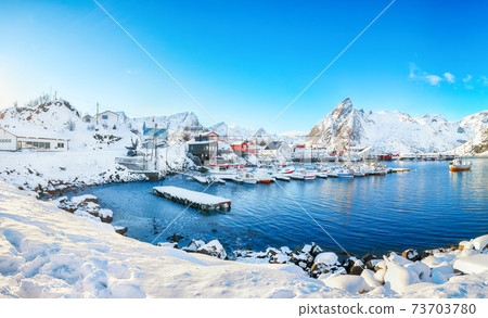 Fantastic winter view on Hamnoy village with port and  Olstinden peak on background. 73703780