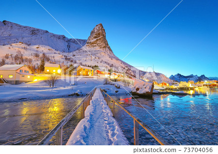 Amazing winter sunset view on Hammarskaftet Mountain Peak with footbridge above Gravdalbukta bay . 73704056