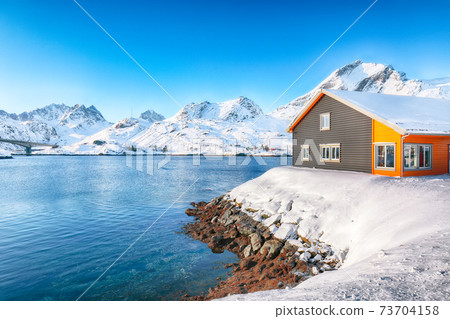 Winter view of small fishing village on Sundstraumen strait and Kakern Bridge Winter view of small fishing village on Sundstraumen strait and Kakern Bridge 73704158