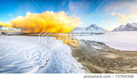 Outstanding  winter scenery on Skagsanden beach with illuminated clouds during sunrise. 73704306
