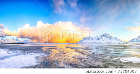 Outstanding  winter scenery on Skagsanden beach with illuminated clouds during sunrise. 73704308