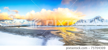 Incredible winter scenery on Skagsanden beach with illuminated clouds during sunrise. 73704309