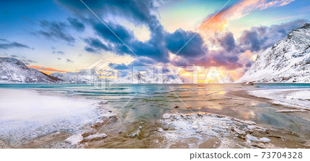 Fantastic winter view of  Haukland beach during sunset with lots of snow  and snowy  mountain peaks near Leknes 73704328