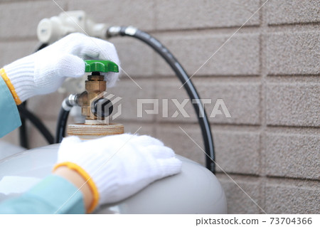 Workers inspecting propane gas cylinders 73704366