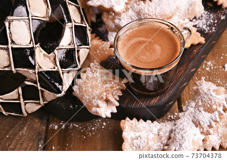 Carnival food TYPICAL and carnival mask. Sfrappole or chiachiere or angel wings and aromatic coffee 73704378