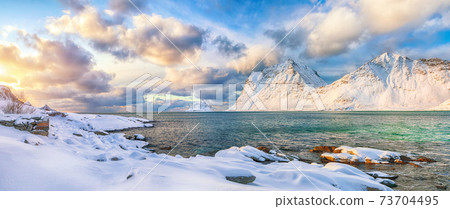 winter view of Vik beach during sunset with lots of snow  and snowy  mountain peaks near Leknes. 73704495