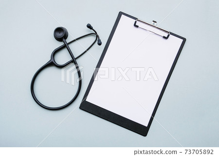 Black stethoscope and blank medical form on grey background. Black stethoscope and blank medical form on grey background. 73705892