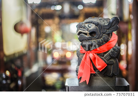 Aggressive smart black lion statue with red scarf. 73707031