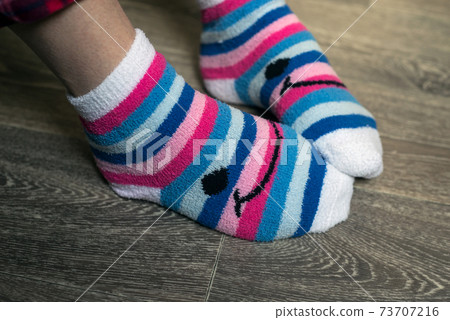 Closeup of pink stripped socks on feet of woman at home Closeup of pink stripped socks on feet of woman at home 73707216