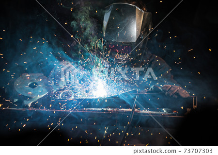 worker with protective mask welding metal 73707303