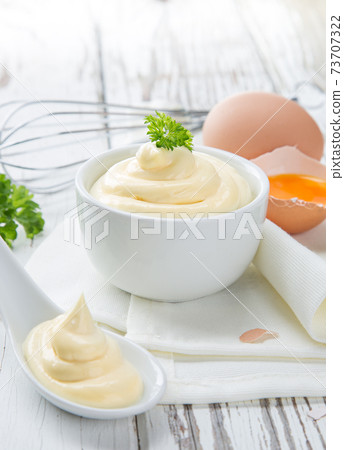 Bowl of Mayonnaise sauce on white wooden table Bowl of Mayonnaise sauce on white wooden table 73707322