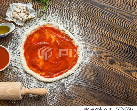 pizza preparation surrounded by ingredients pizza preparation surrounded by ingredients 73707323