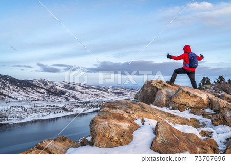 hiking at dawn over frozen mountain lake 73707696