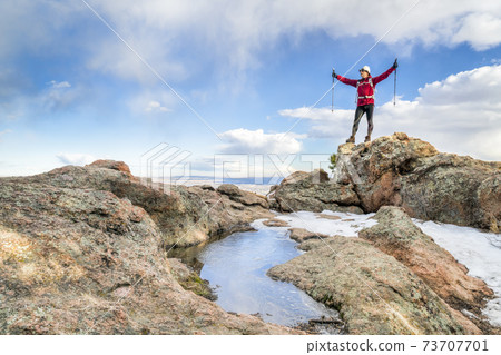 hiker enjoying reaching mountain top 73707701
