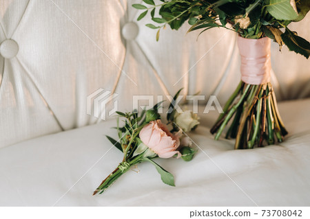 wedding bouquet with peonies and roses on a chair and boutonniere.The decor at the wedding 73708042