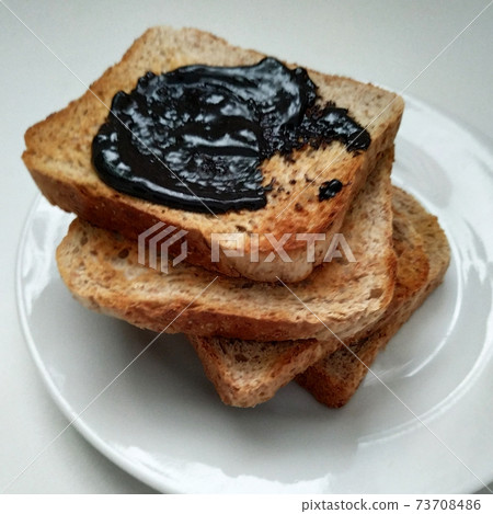 Delicious toasts with chocolate for breakfast before coffee, toasts on a white plate, dried bread on a white background. Delicious toasts with chocolate for breakfast before coffee, toasts on a white plate, dried bread on a white background. 73708486