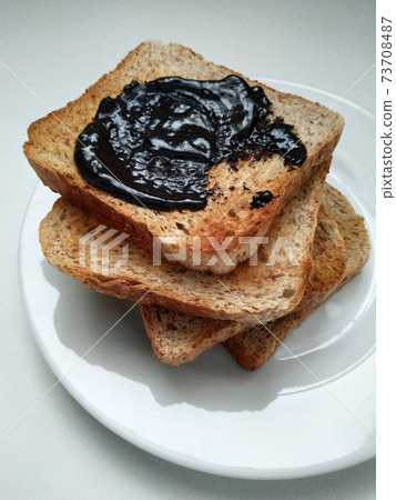 Delicious toasts with chocolate for breakfast before coffee, toasts on a white plate, dried bread on a white background. Delicious toasts with chocolate for breakfast before coffee, toasts on a white plate, dried bread on a white background. 73708487