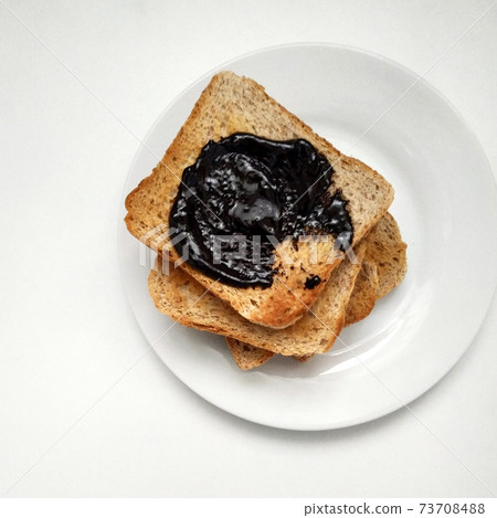 Delicious toasts with chocolate for breakfast before coffee, toasts on a white plate, dried bread on a white background. Delicious toasts with chocolate for breakfast before coffee, toasts on a white plate, dried bread on a white background. 73708488