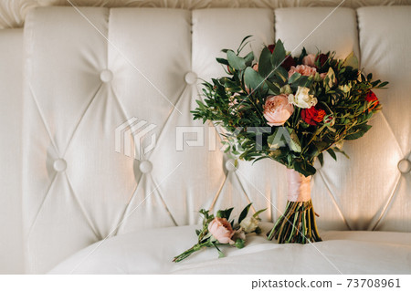 wedding bouquet with roses and boutonniere.The decor at the wedding 73708961
