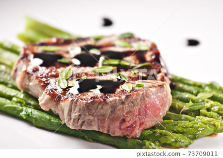 Fillet of beef with asparagus on a plate. 73709011