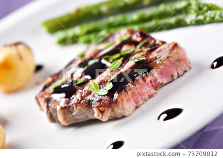 Fillet of beef with asparagus and potatoes on a plate. 73709012