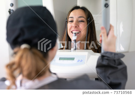 Young woman patient standing in x-ray machine. 73710568