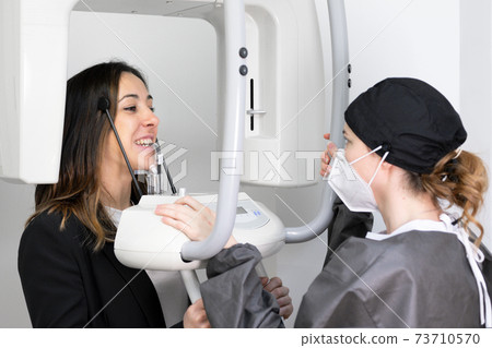 Young woman patient standing in x-ray machine. 73710570