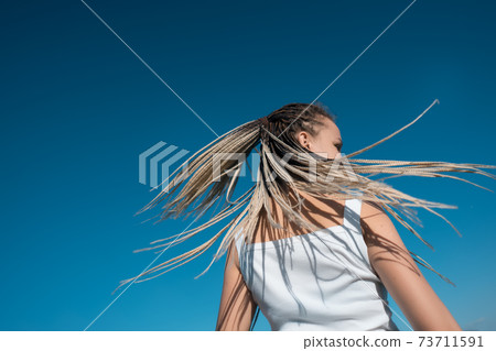 Beautiful woman waving hair with stylish afro braids 73711591