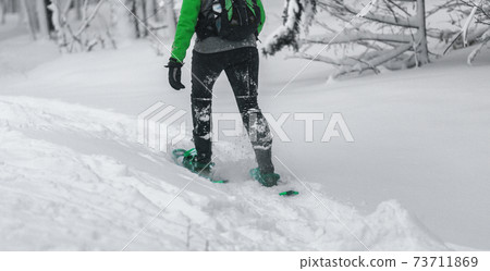 Snowshoe closeup of woman hiker snowshoeing in snow. Winter outdoor activity, winter sports Snowshoe closeup of woman hiker snowshoeing in snow. Winter outdoor activity, winter sports 73711869