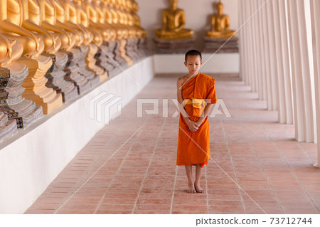 Young novice monk walking for meditation at Wat Phutthai Sawan temple, Ayutthaya, Thailand 73712744