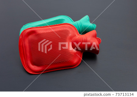 Hot water bags on dark background. Hot water bags on dark background. 73713134
