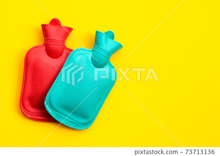 Hot water bags on yellow background. 73713136