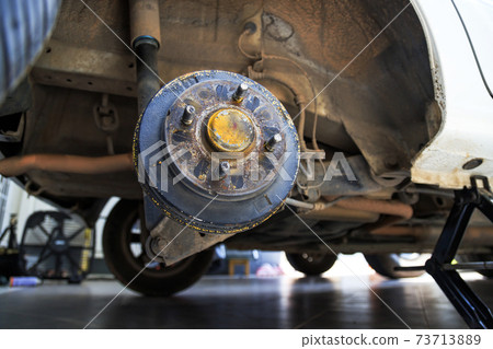 A rear hub of the car after removing a tire and wheel, maintaining a brake and wheel system, car jack-up for change a car wheel, Close-up shot 73713889
