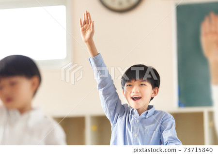Elementary school students raising their right hand in the classroom 73715840