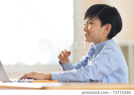 A smiling boy using a laptop A smiling boy using a laptop 73715880
