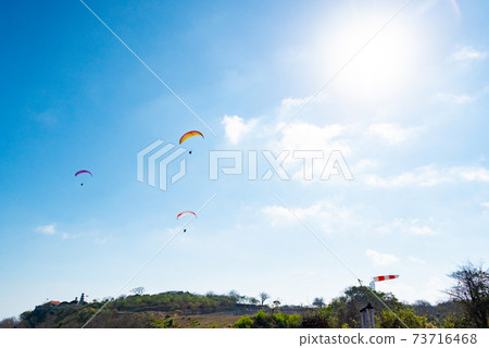 巴拉滑翔機和太陽在藍色夏日的天空中飛翔 73716468