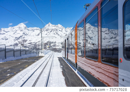The "GornergratBahn" train from Zermatt towards Gornergrat station.Famous electric red tourist train in Zermatt,Switzerland,Europe.The Gornergratbahn is a 9 km. long gauge mountain rack railway. 73717028