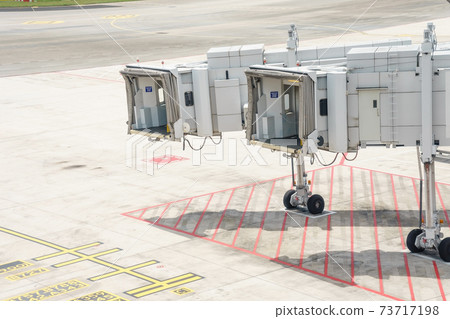Airplane bridge in airport for passengers boarding or Jetway waiting for a plane to arrive on airport or airport terminal boarding gate. Airplane bridge in airport for passengers boarding or Jetway waiting for a plane to arrive on airport or airport terminal boarding gate. 73717198