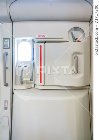 Closeup shot of Emergency exit on an aircraft, view from inside of the plane. 73717200