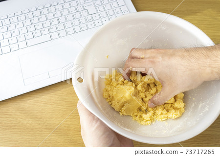 看一台膝上型計算機和做曲奇餅的一個人的圖像 看一台膝上型計算機和做曲奇餅的一個人的圖像 73717265