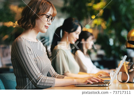Woman working in coworking space Woman working in coworking space 73717311