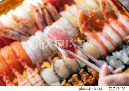 A lot of sushi packed in a tub 73717401