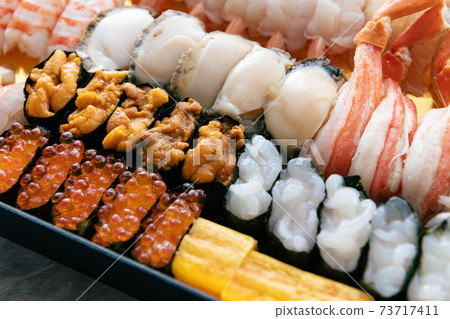A lot of sushi packed in a tub 73717411