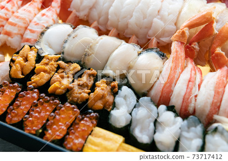 A lot of sushi packed in a tub A lot of sushi packed in a tub 73717412