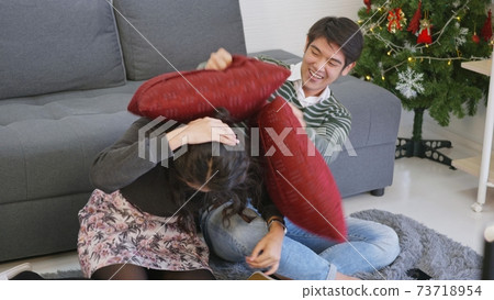 husband and wife smile and laugh enjoying funny fighting with pillows 73718954